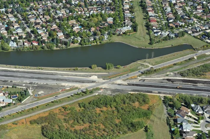 Chief Peguis Trail construction beside water and neighbourhoods